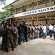 Guinean soldiers and civilians queue to cast their votes in Conakry.